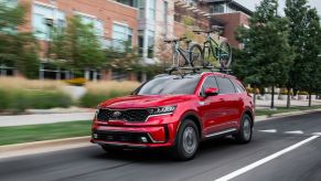 A red 2021 Kia Sorento Hybrid driving in the city