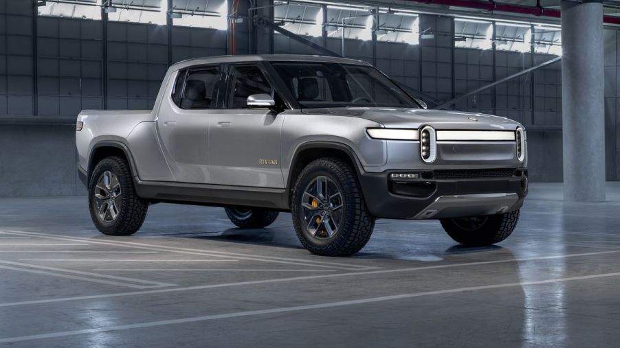 A silver 2021 Rivian R1T on display in an empty warehouse