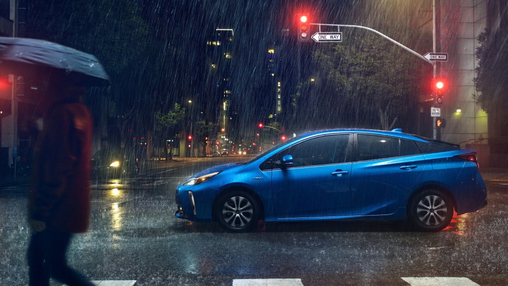2021 Toyota Prius in blue parked in the rain in a city