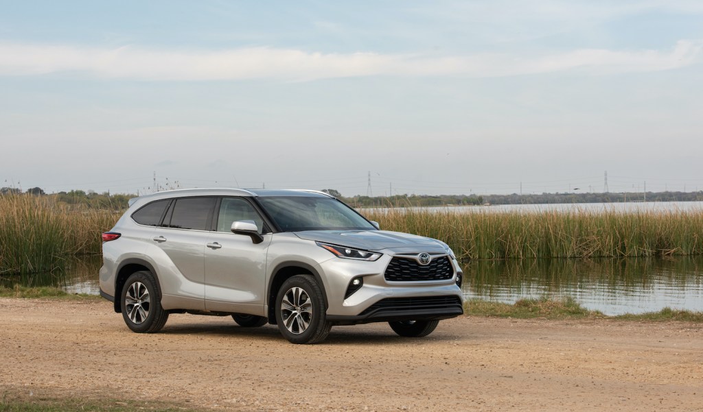 A silver 2021 Toyota Highlander SUV parked near a picturesque pond
