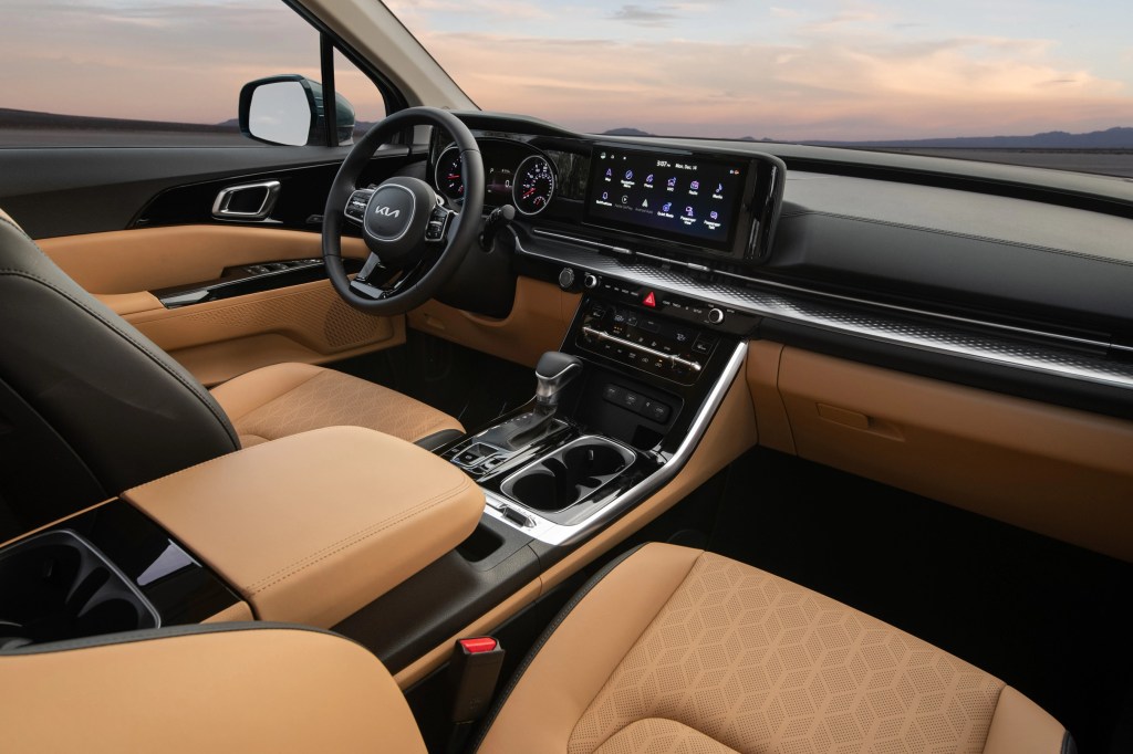 The brown-leather front seats and black dashboard of a 2022 Kia Carnival SX Prestige