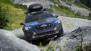 2022 Subaru Outback Wilderness Edition driving up a craggy rock