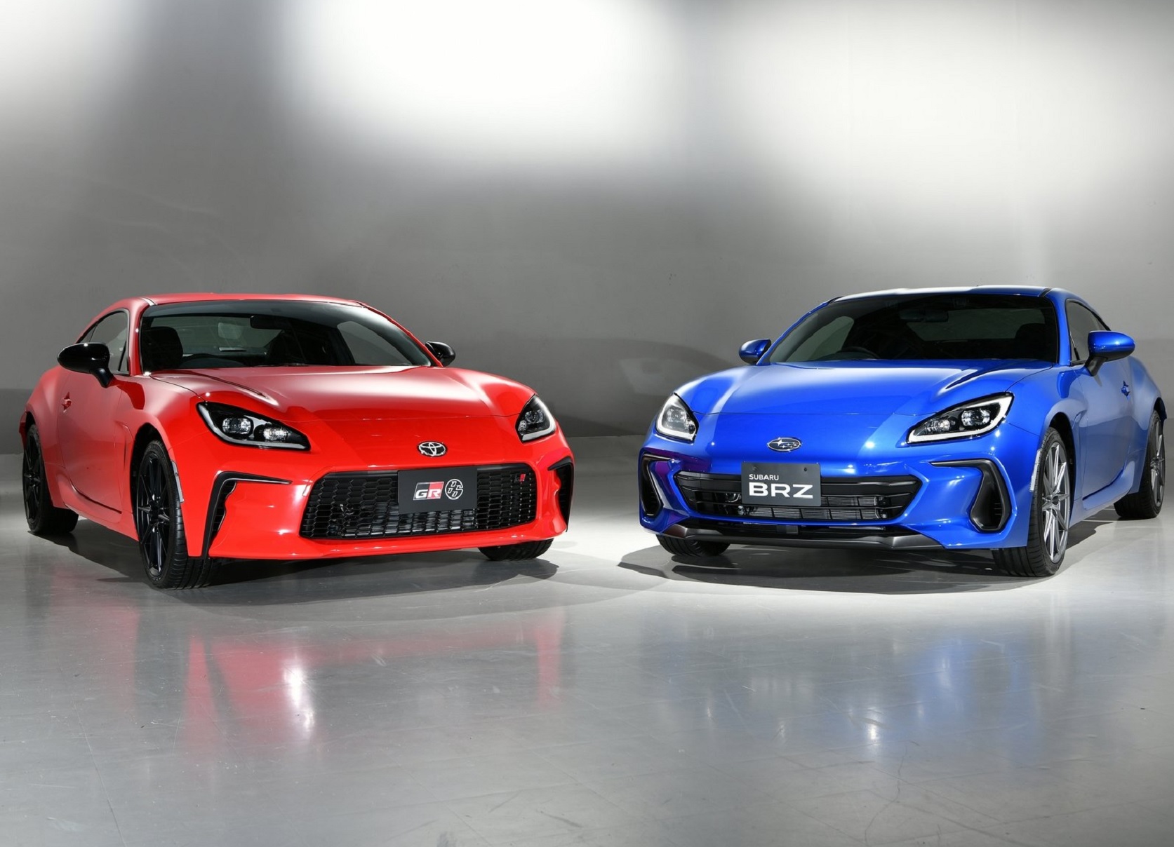 A red 2022 Toyota GR 86 next to a blue 2022 Subaru BRZ