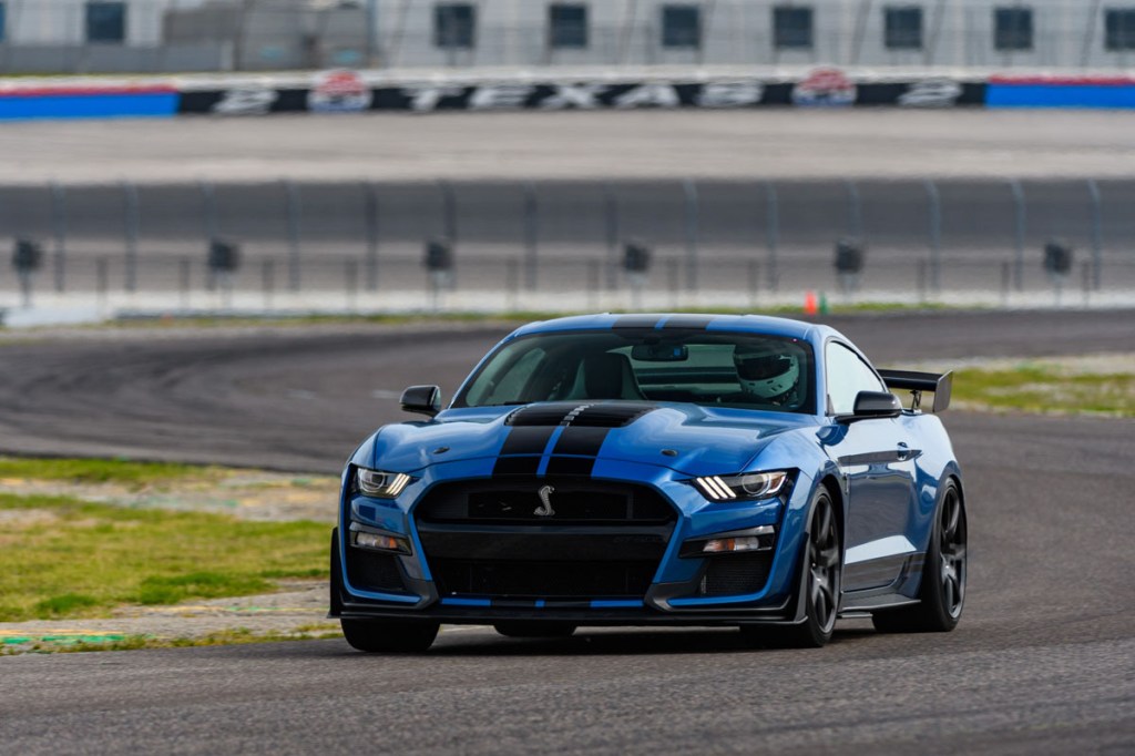 A Shelby GT500 in bright blue paint driving on a track