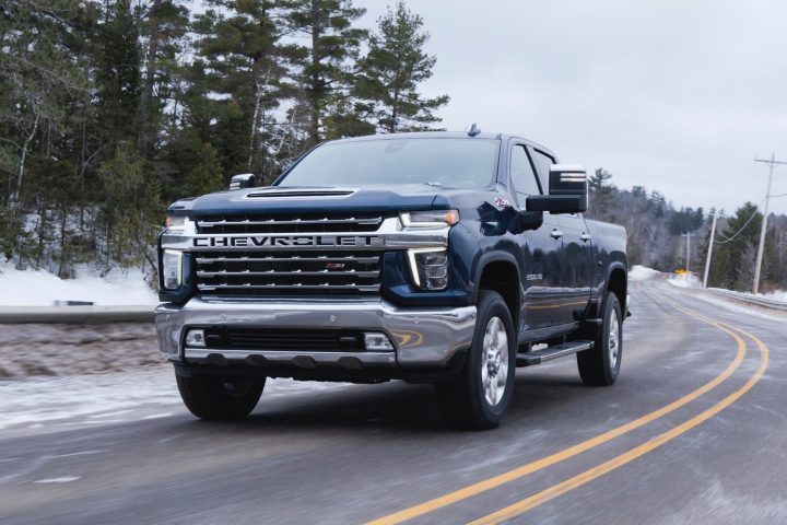 Chevrolet Silverado 2500 HD driving on a wintery forest road