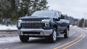 Chevrolet Silverado 2500 HD driving on a wintery forest road
