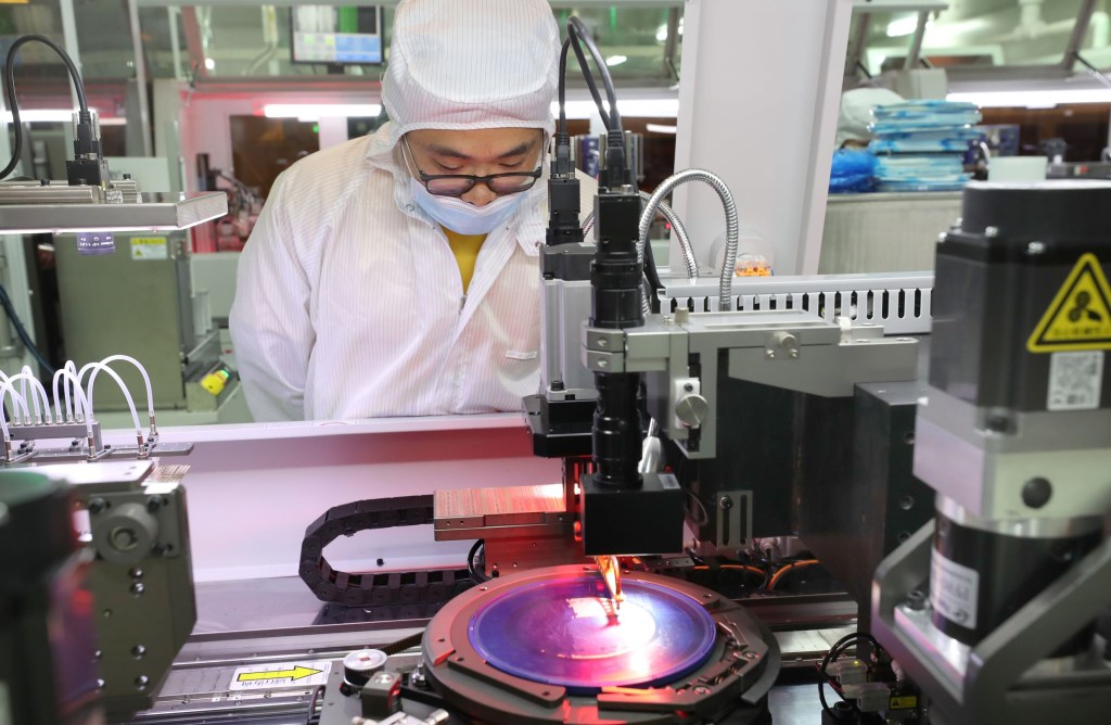 A Jiejie Semiconductor employee makes a silicon wafer destined for microchips in Nantong, China