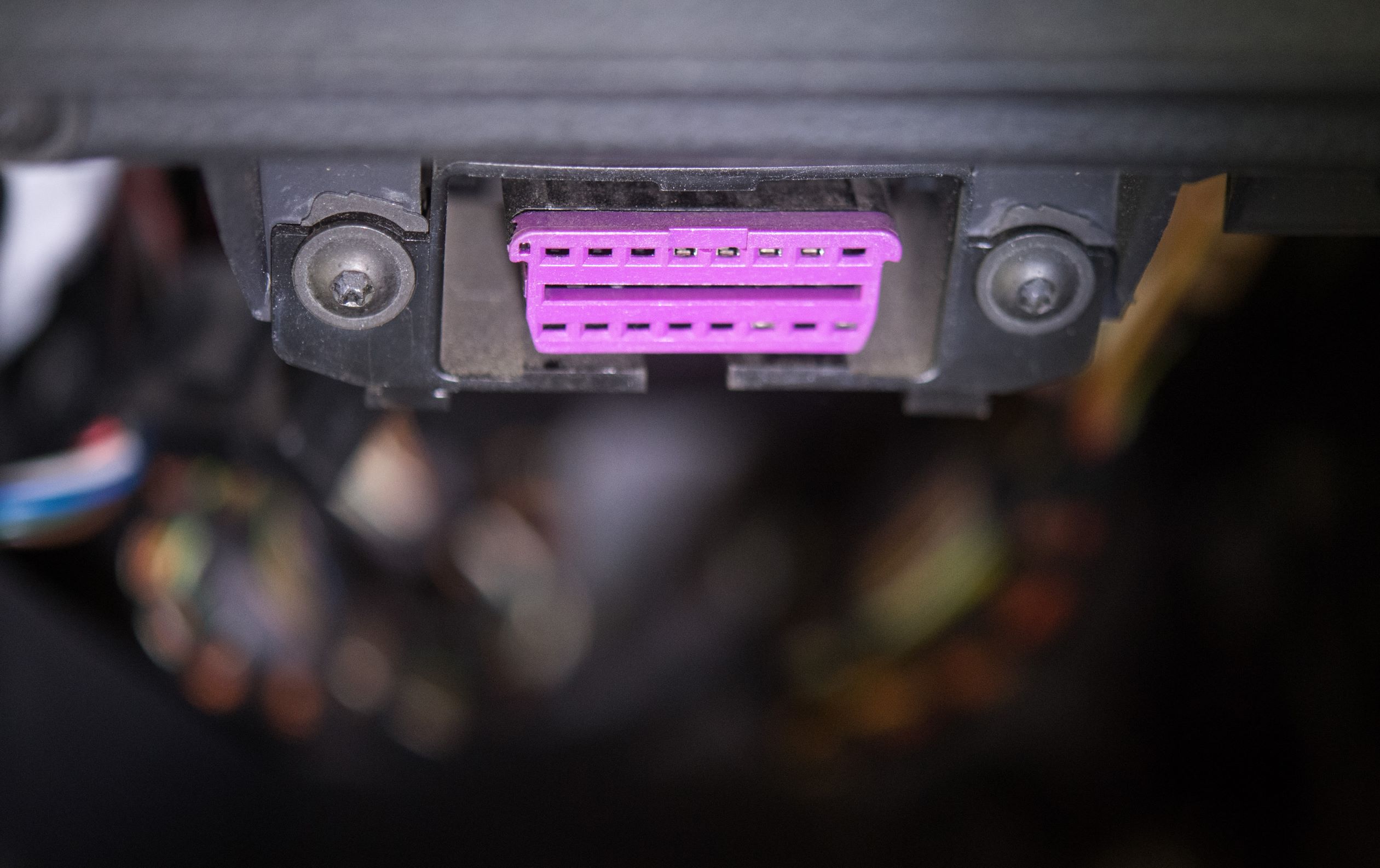 A car's pink-purple OBD-II port