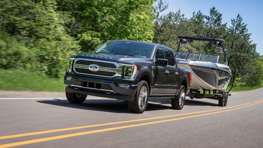 The 2021 Ford F-150 towing a boat on the road