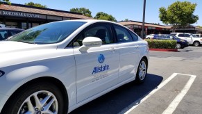 An blue Allstate insurance logo on a white sedan in Dublin, California, on a sunny day in July 2018