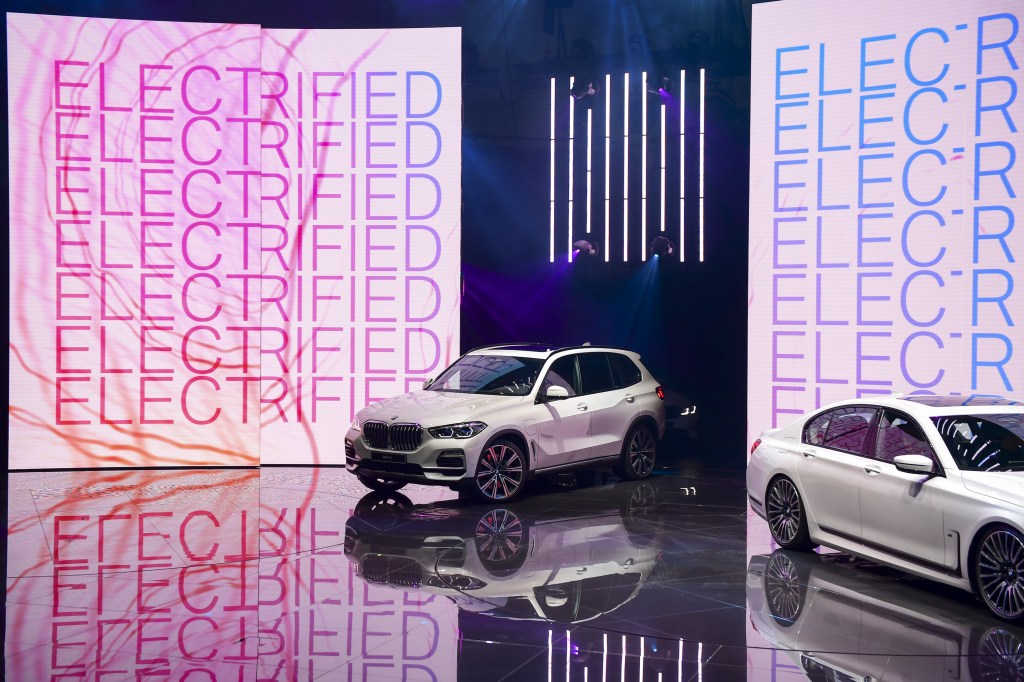 The Bayerische Motoren Werke AG white (BMW) X5 xDrive45e plug-in hybrid sports utility vehicle (SUV) is driven on to a stage on the opening day of the 89th Geneva International Motor Show