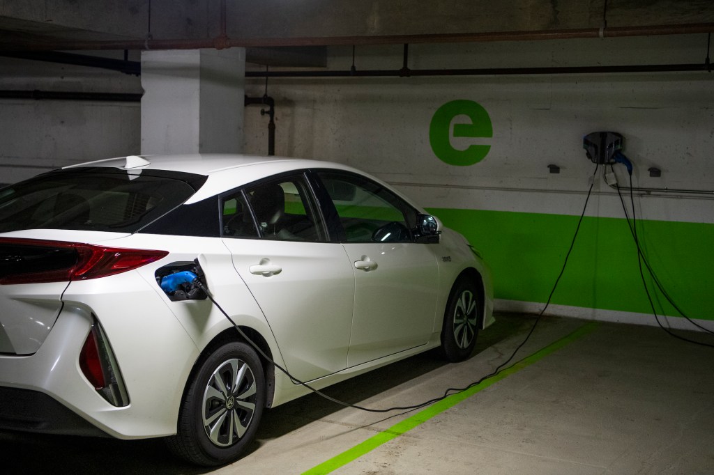 A white Toyota Prius connected to an EV charging station in a Washington, D.C. parking garage on Wednesday, March 31, 2021
