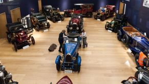 Two employees get some antique and vintage cars ready for an online Bonhams October 2020 auction