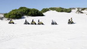 ATV riders traversing scenic sand dunes