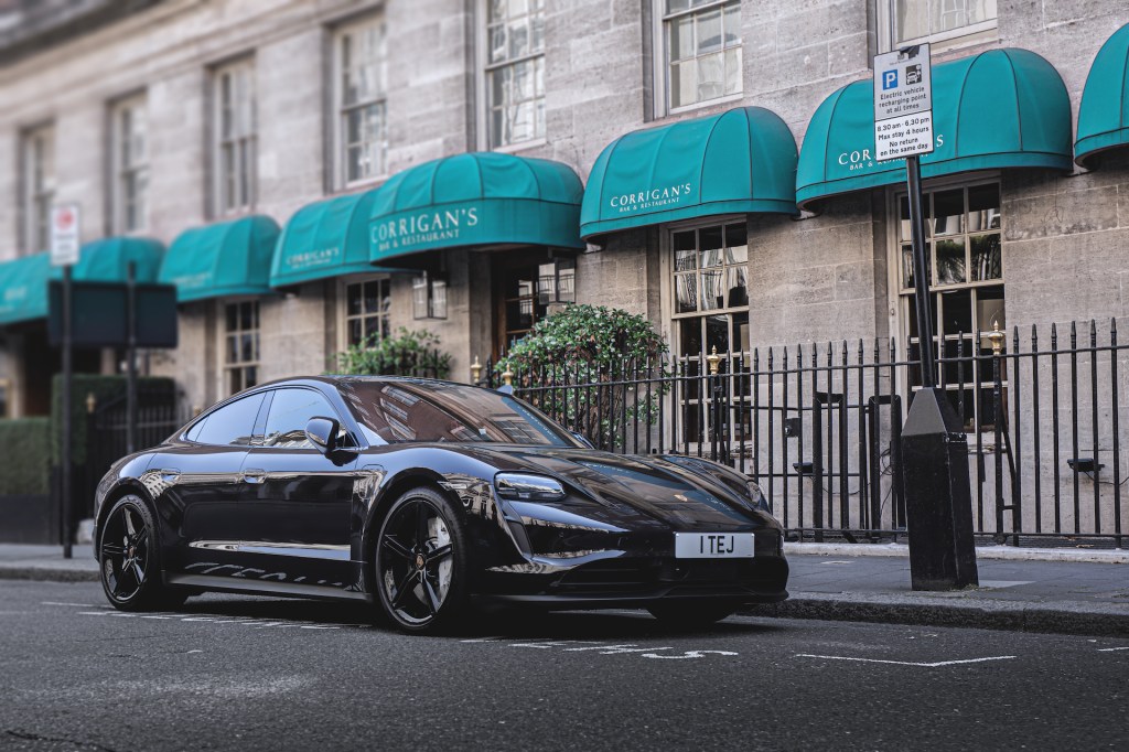 An image of a Black Porsche Taycan parked outdoors in one of the worst car colors for resale.