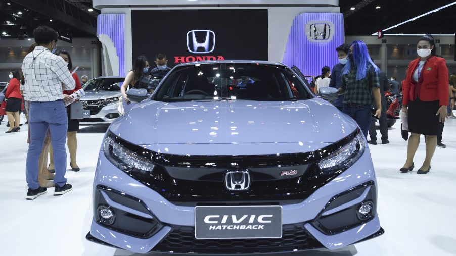People look at gray Honda Civic cars during at the 42nd Bangkok International Motor Show 2021 in Bangkok, Thailand
