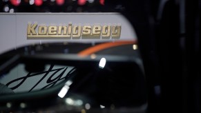 A Koenigsegg logo sits on a wall beyond the automaker's Agera RS hypercar at the 85th Geneva International Motor Show in Geneva, Switzerland, on Wednesday, March 4, 2015