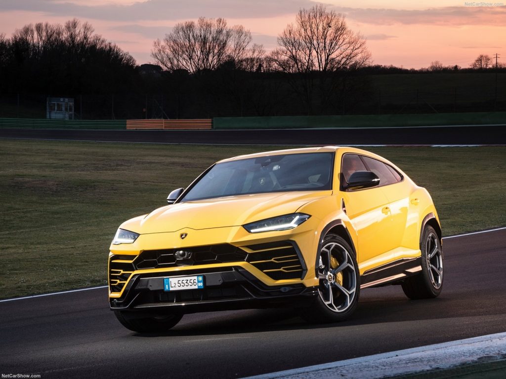 A yellow 2021 Lamborghini Urus parked on a racetrack