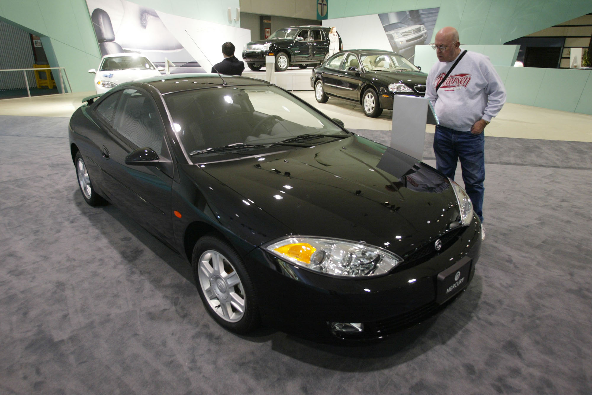 Harlan Curtis examines a black Mercury Cougar coupe at the Los Angeles Auto Show on January 11, 2001, in Los Angeles