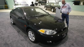 Harlan Curtis examines a black Mercury Cougar coupe at the Los Angeles Auto Show on January 11, 2001, in Los Angeles