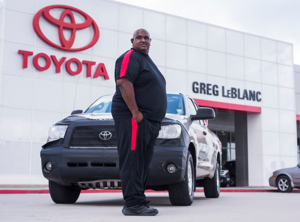 Victor Sheppard pictured with his Toyota Tundra pickup in front of a Toyota dealership.