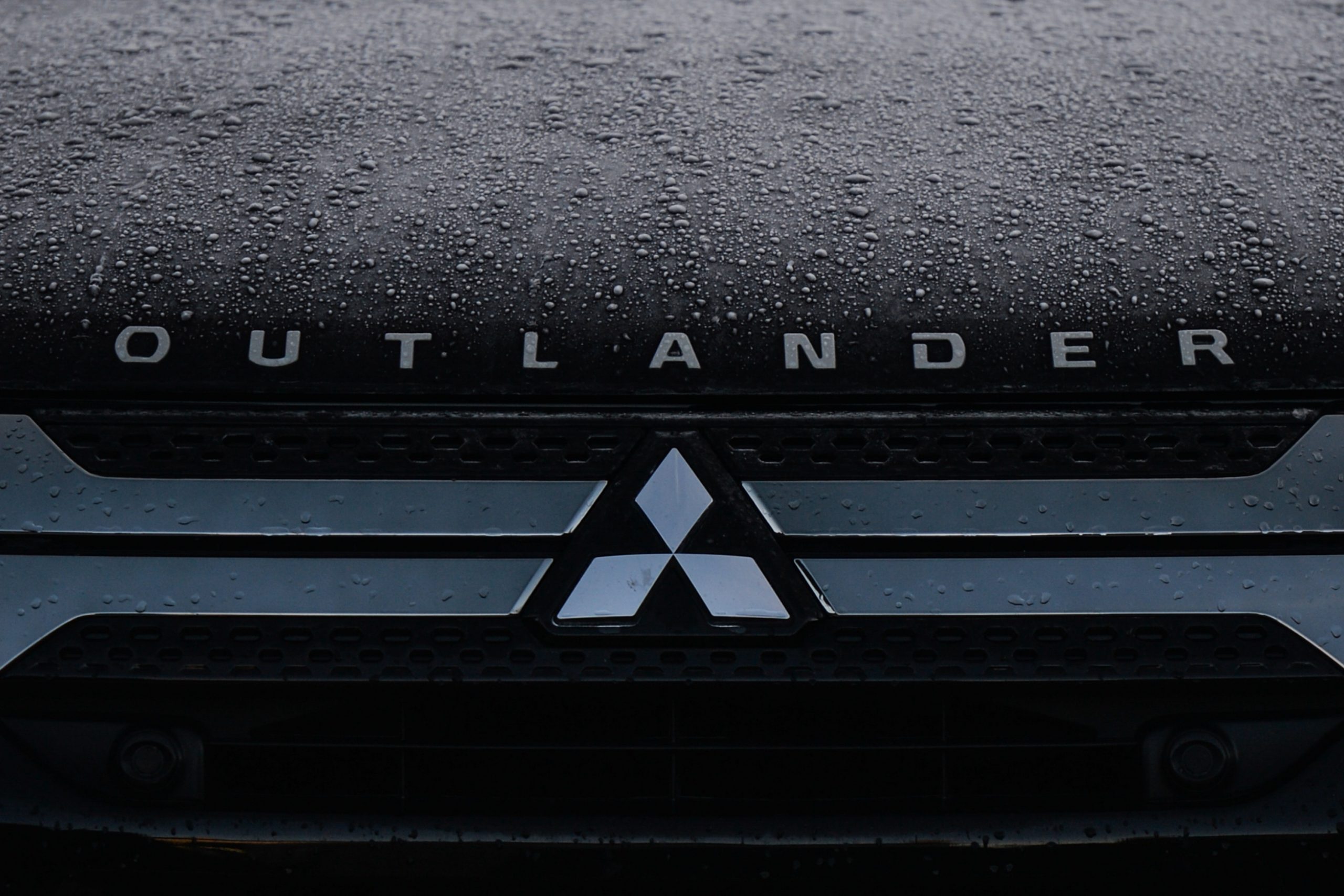 A Mitsubishi logo seen on a parked 2022 Mitsubishi Outlander car in Dublin city center.