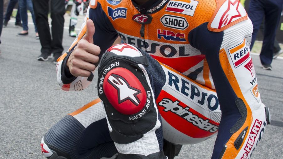 Orange-liveried MotoGP racer Marc Marquez shows off his white-and-black Alpinestars motorcycle track boots