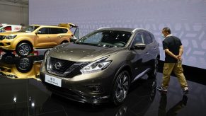 A man looks at a Nissan Murano car displayed at the Beijing Auto Show in Beijing