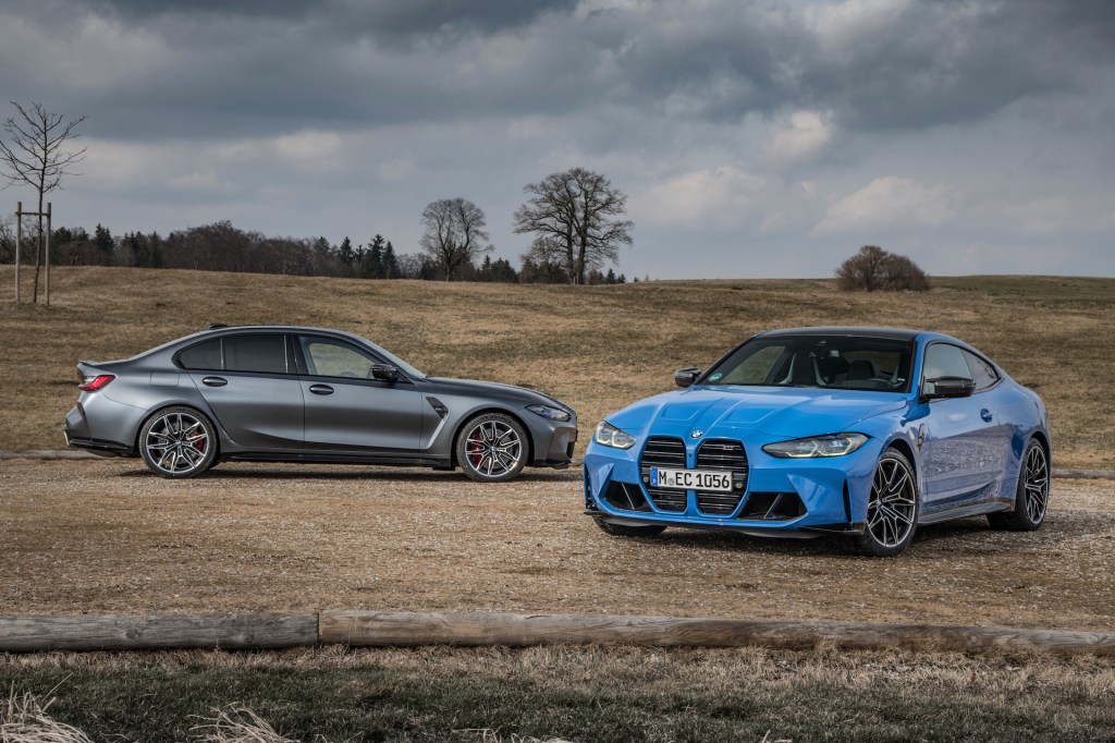 An image of a BMW M3 and M4 xDrive parked outside.