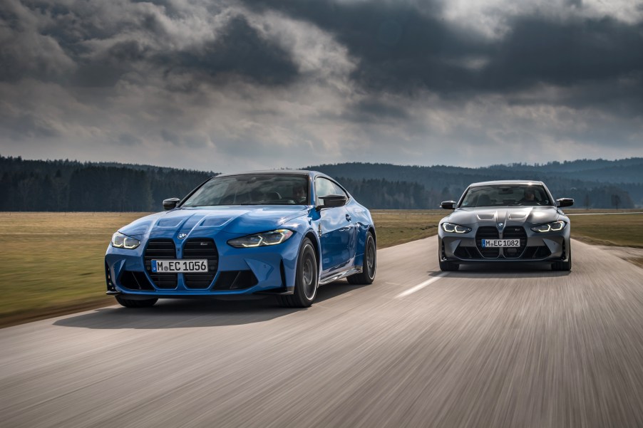 An image of a BMW M3 and M4 xDrive driving on a road.