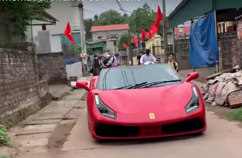 Phony Ferrari driving down narrow Vietnamese street