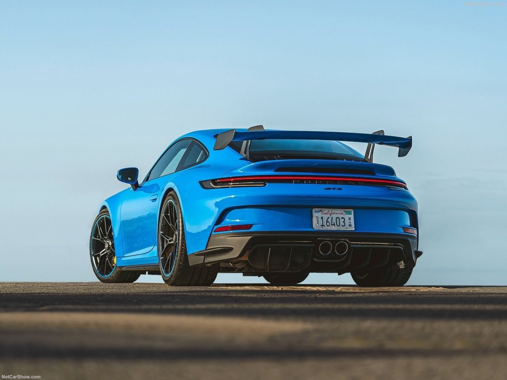 The rear view of a blue 2022 Porsche 911 GT3 on a track.