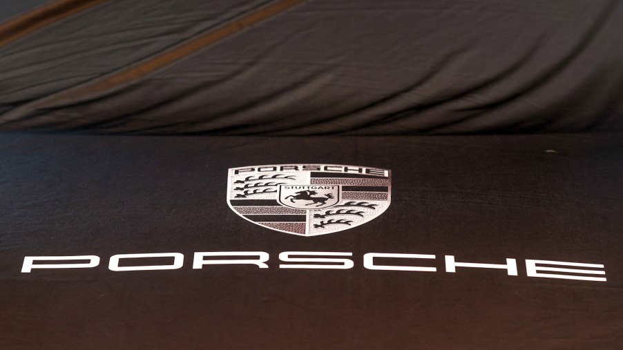 A Porsche logo sits on a covered automobile in the showroom at the Porsche Automobil Holding SE center in Hamburg, Germany, on Wednesday, August 5, 2020