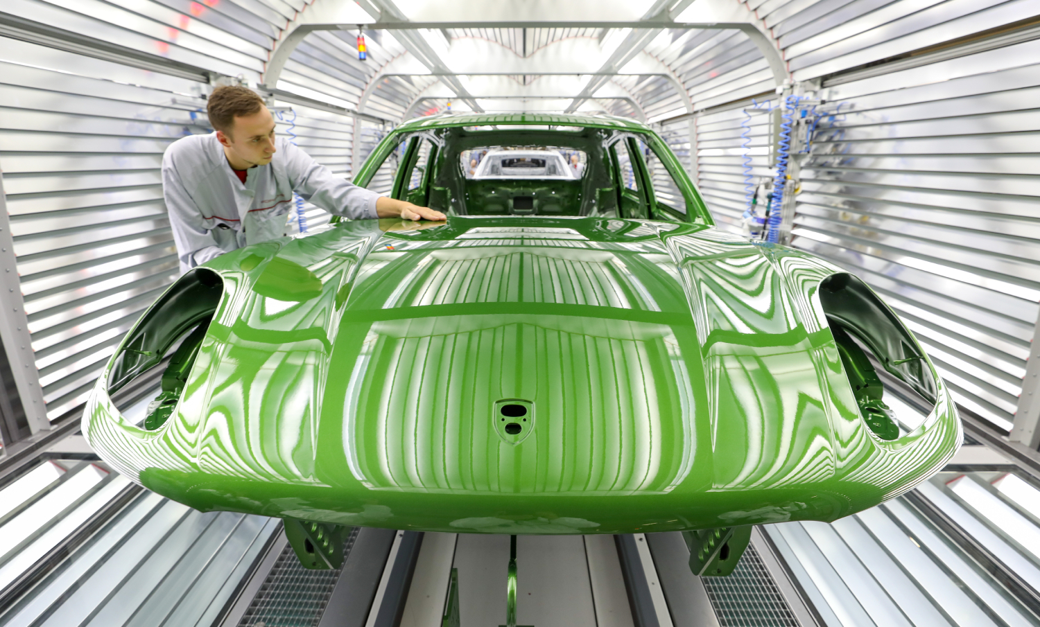 A bright green Porsche Macan on the assembly line
