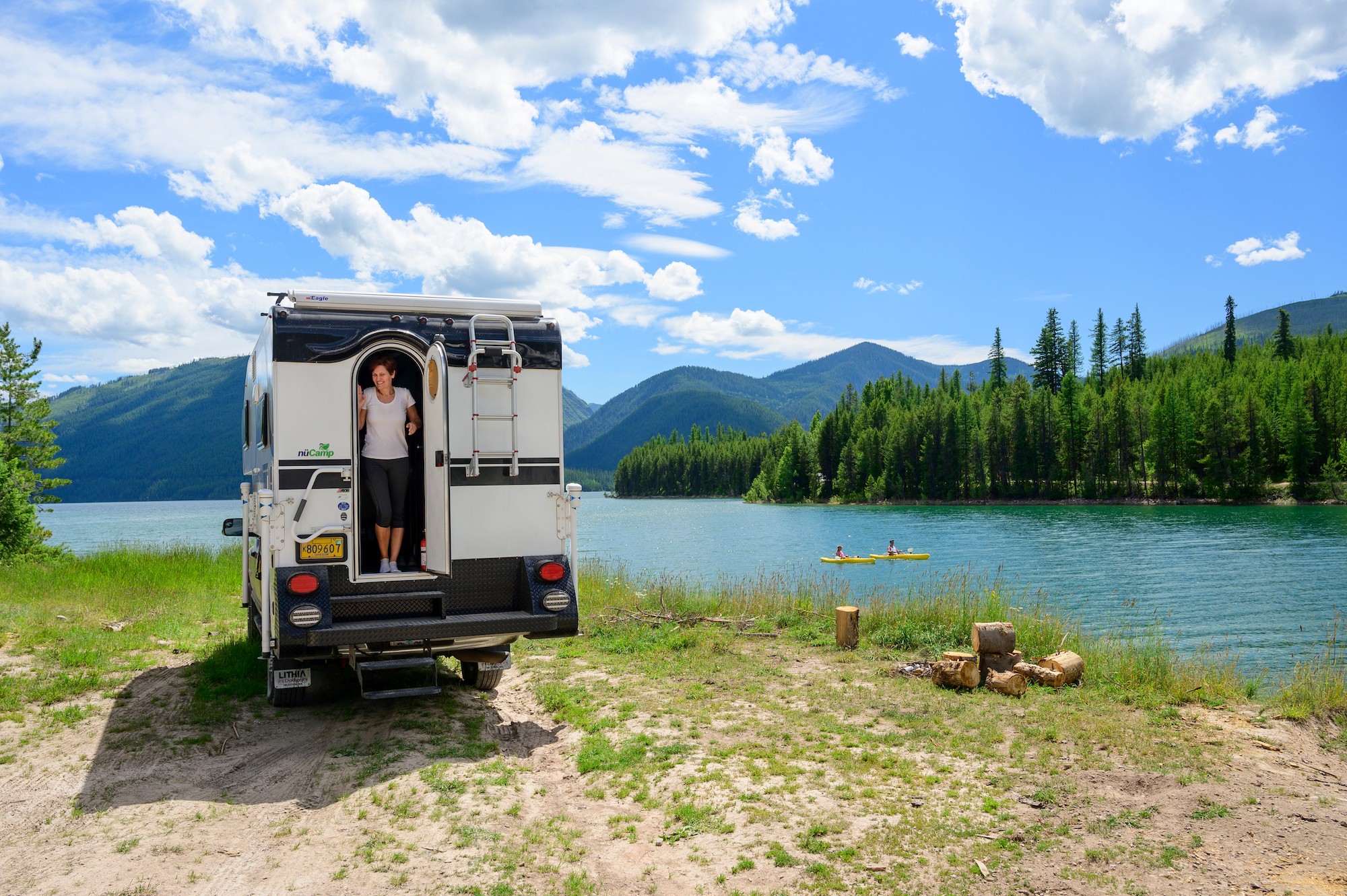 An RV campsite overlooking Hungry Horse Reservoir, South Fork Flathead River, and the Rocky Mountains in northwest Montana on a sunny day