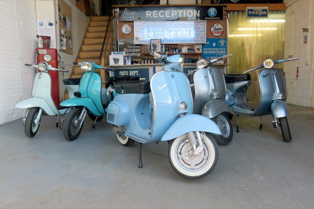 Several Retrospective Scooters Project E electric vintage Vespa scooters in a garage
