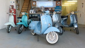 Several Retrospective Scooters Project E electric vintage Vespa scooters in a garage
