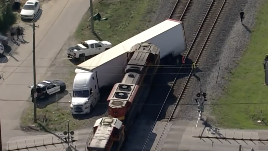 An image of a train crashing into a semi truck.