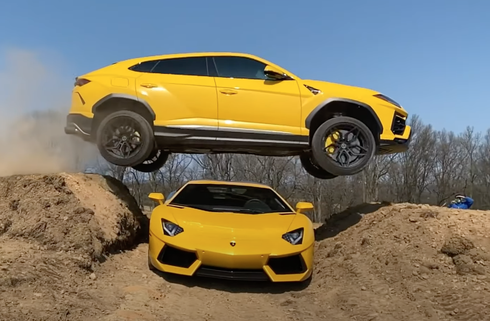 An image of a yellow Lamborghini Urus jumping over an Aventador.