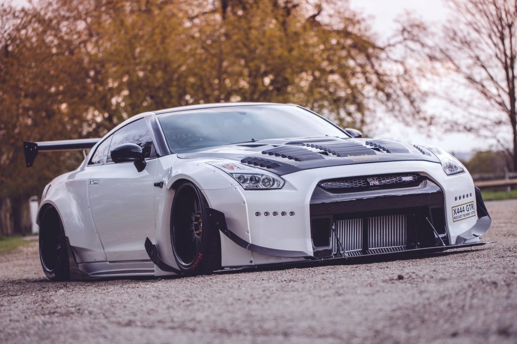 Starlite Limos' black-and-white R35 Nissan GT-R with a Rocket Bunny body kit parked in an English countryside manor garden