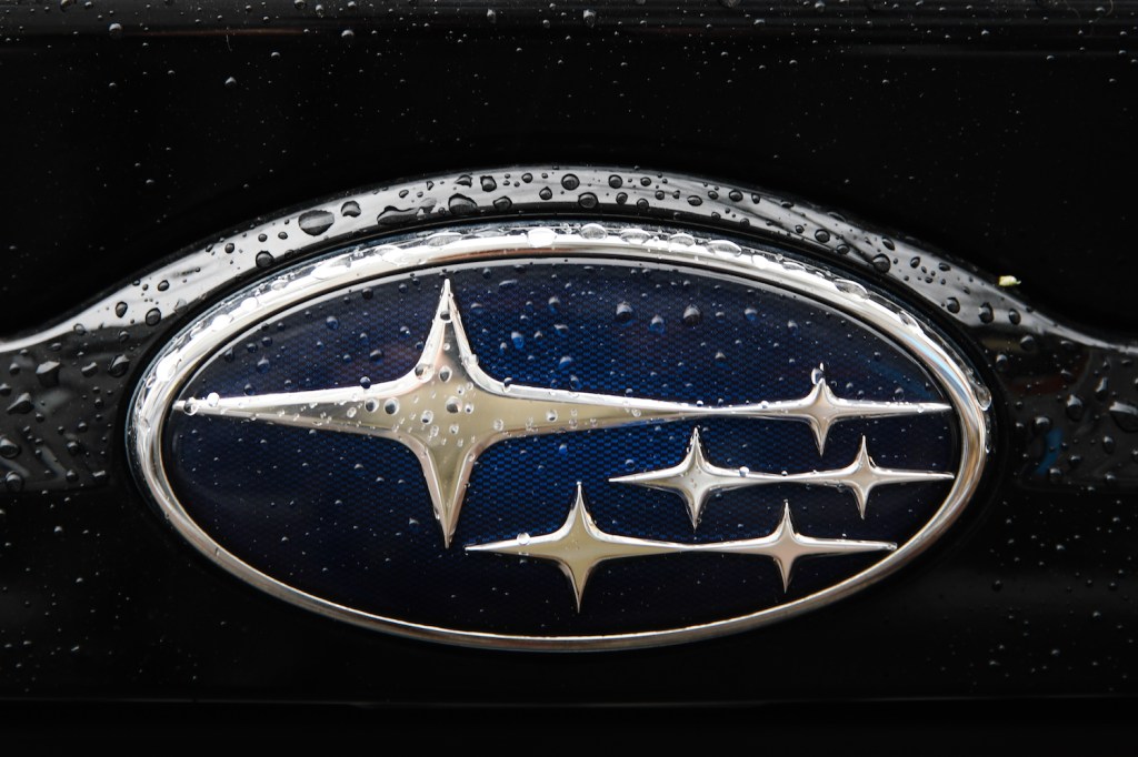 The Subaru Logo with flecks of water on it.
