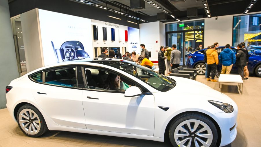 A white Tesla Model 3 vehicle is seen at a Tesla flagship store