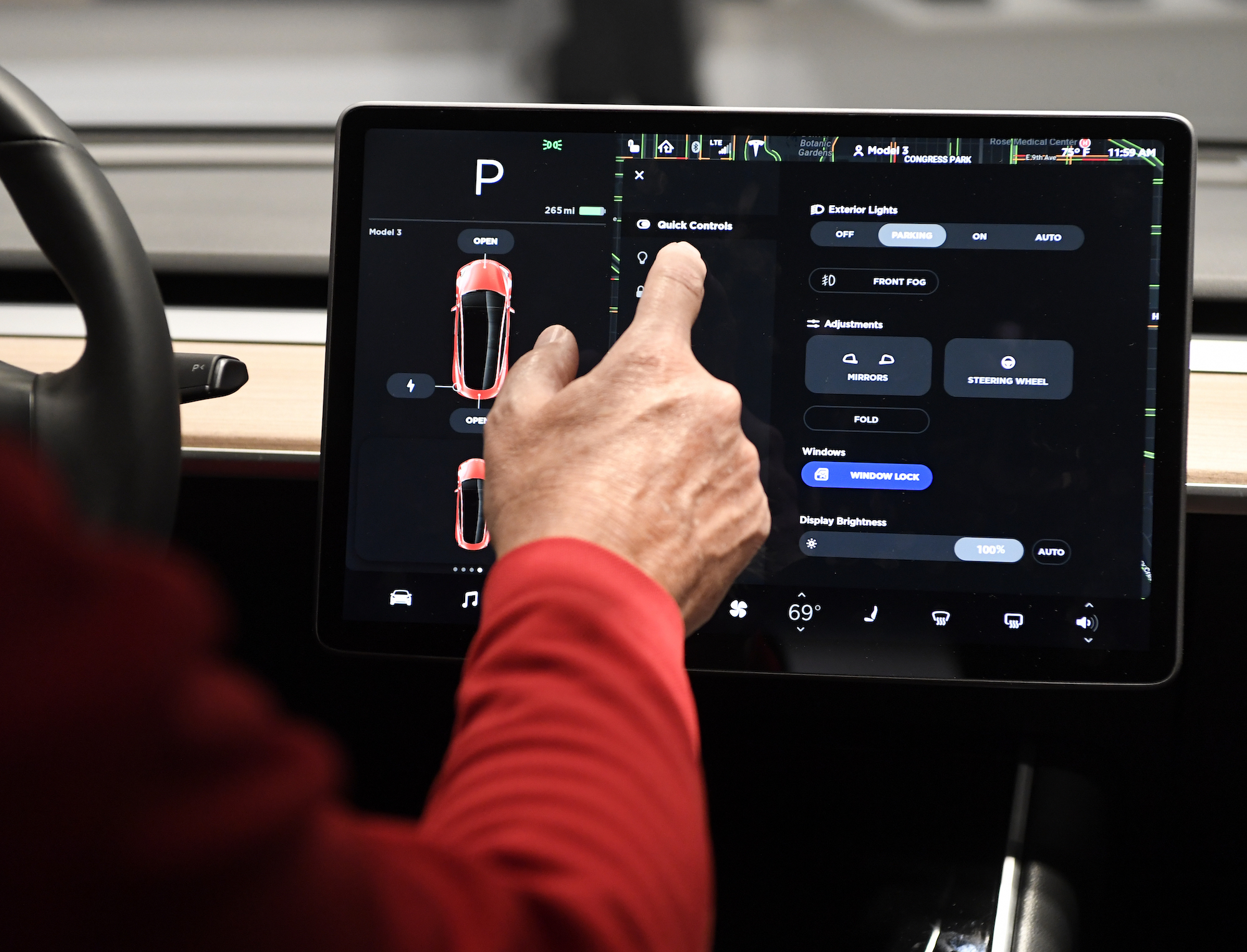 A man's finger touches a Tesla Model 3's 15-inch control touchscreen in May 2018