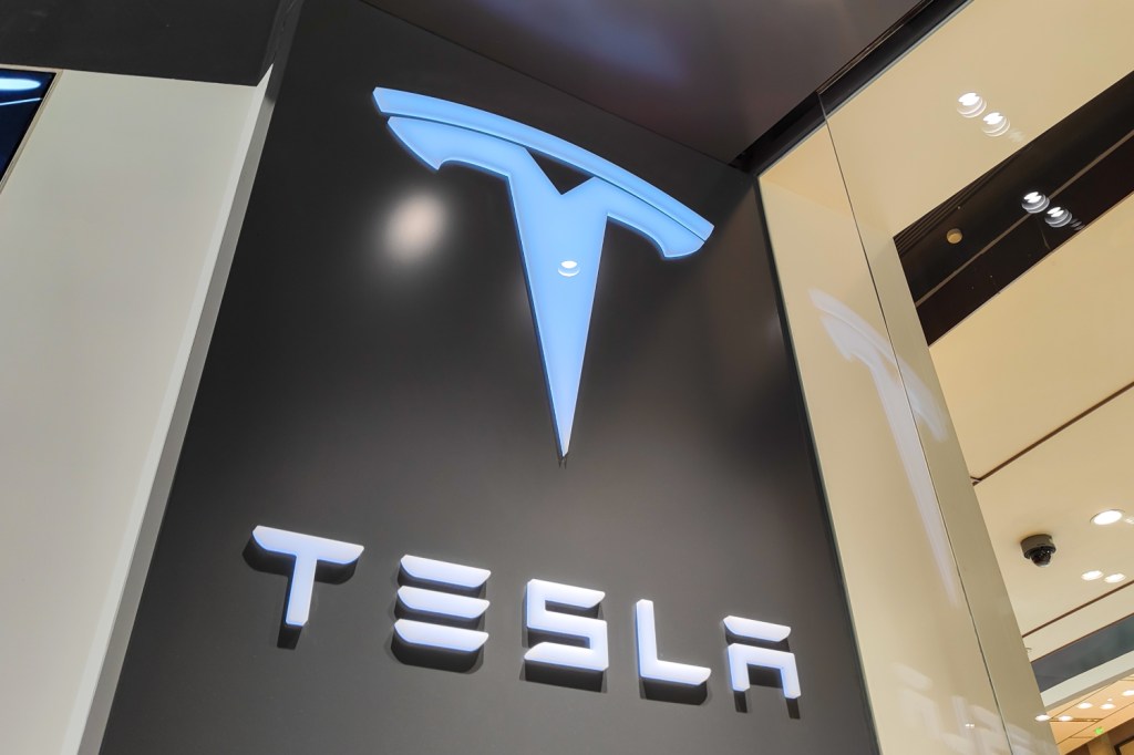 A Tesla sign lit up at a store