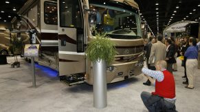 A woman takes a picture of an RV at a trade show