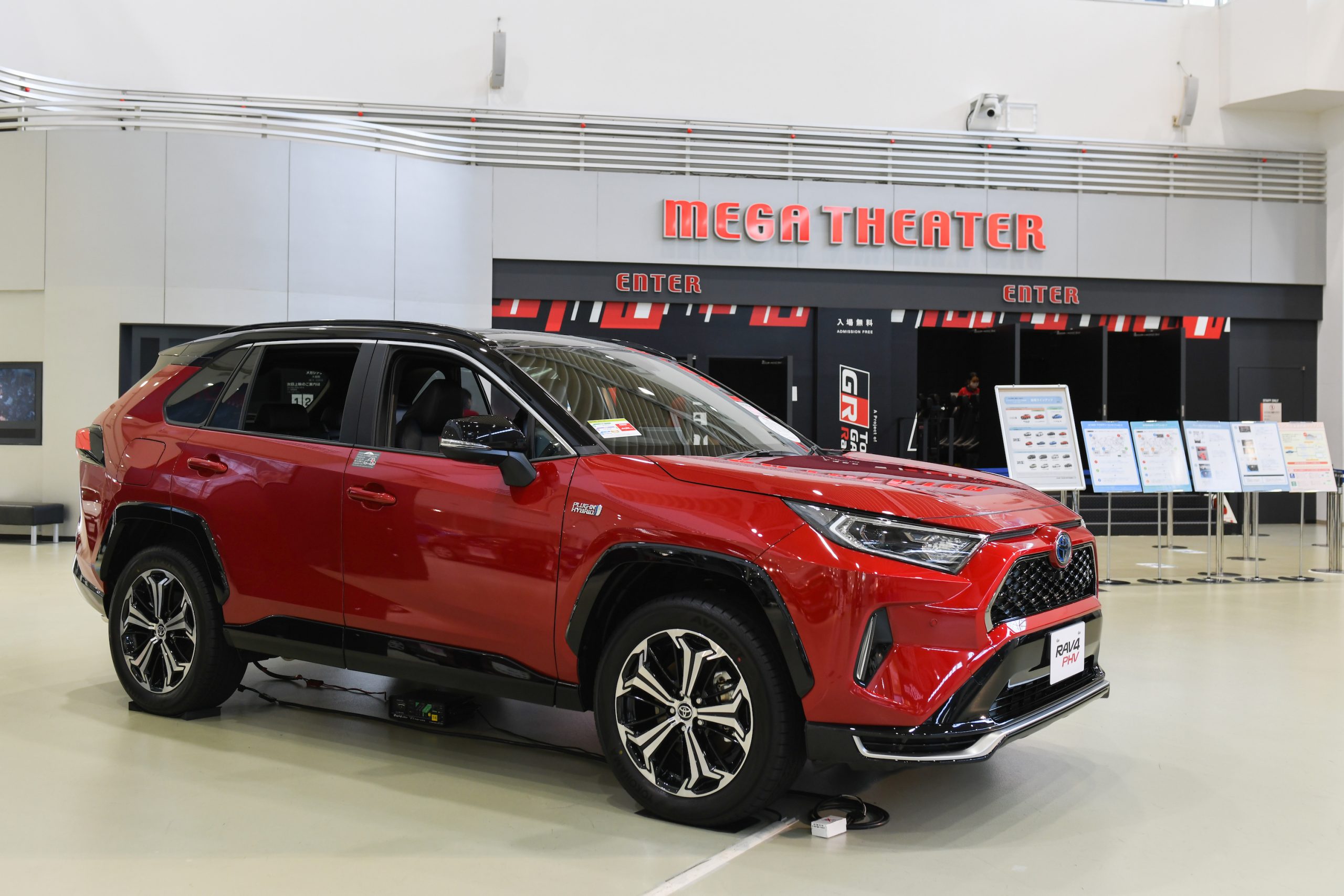 A red Toyota Motor Corp. RAV4 plug-in hybrid sports utility vehicle (SUV) stands on display at the Toyota Mega Web showroom in Tokyo, Japan