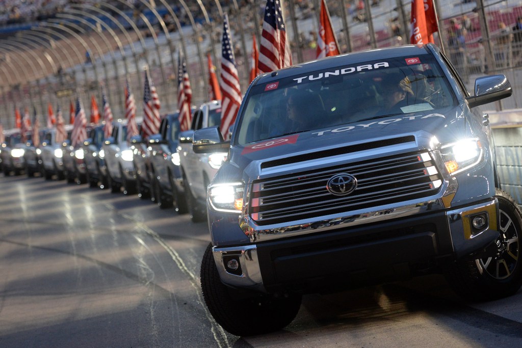 A lineup of Toyota Tundra pickup trucks driving a few miles around a track.