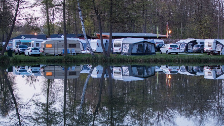 Travel trailers and other RVs at a camping site overlooking a lake