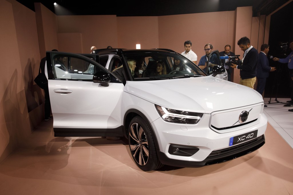 Members of the media view the white Volvo XC40 Recharge electric sports utility vehicle (SUV) during an unveiling event in Los Angeles, California, U.S.