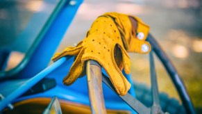 Yellow leather driving gloves on the steering wheel of a Bugatti Type 43 classic sports car of the 1920s on display at the 2019 Concours d'Elegance at palace Soestdijk on August 25, 2019, in Baarn, Netherlands